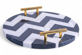 Round marble tray with gold handles featuring a blue and white chevron pattern on a white background.