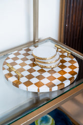 Checkered tray with gold accents on a glass surface