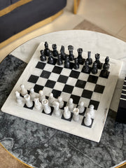 Chessboard with black and white pieces on a marble surface