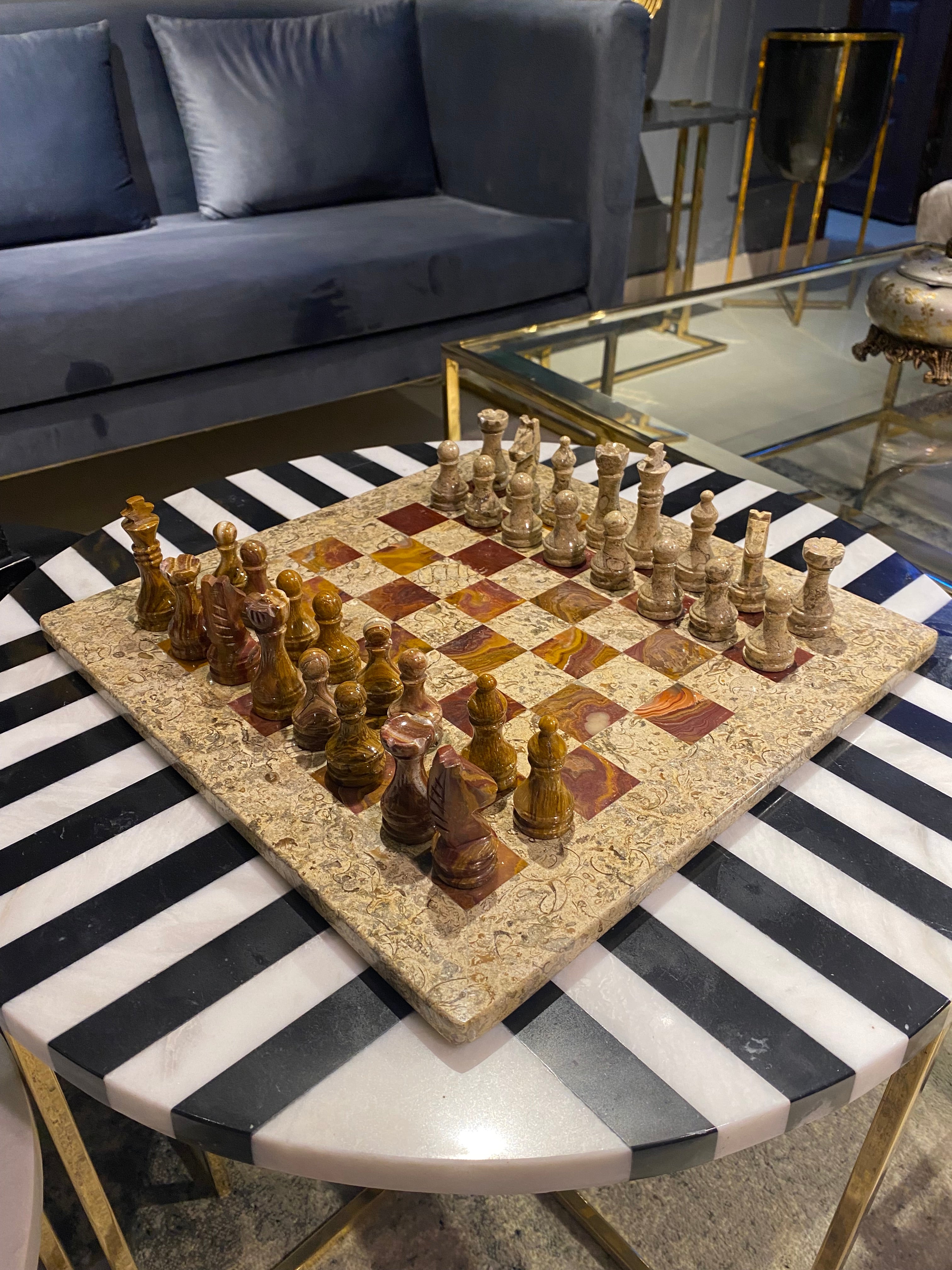 Decorative chess set on a black and white striped surface with a blurred indoor background