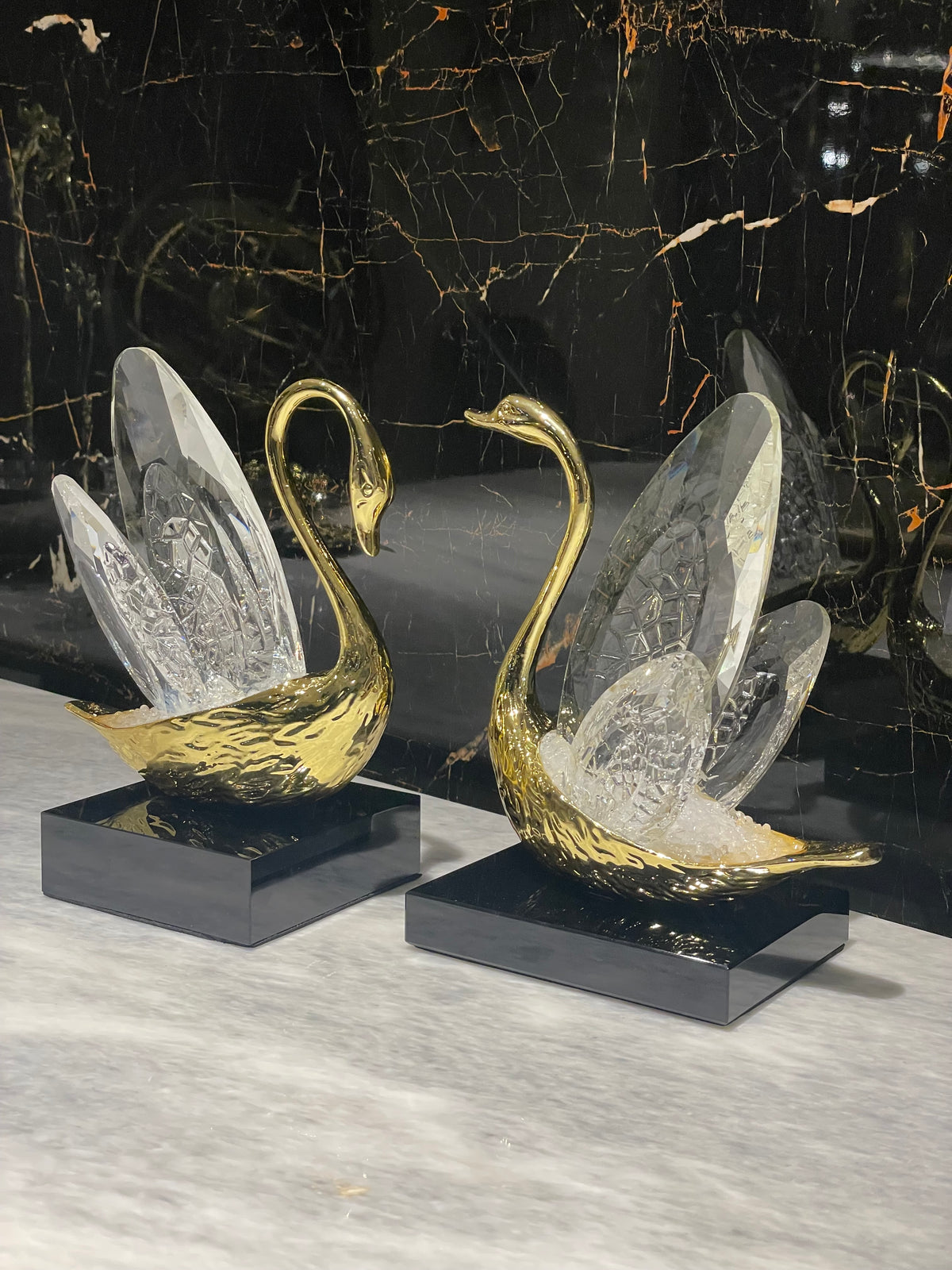 Decorative swan sculptures on a black marble surface