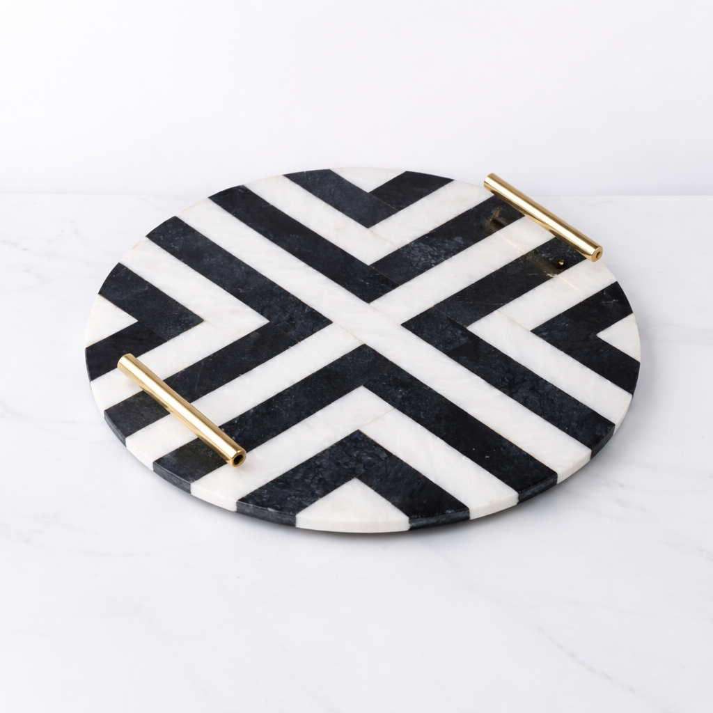 Round decorative plate with black and white chevron pattern and gold accents on a white background