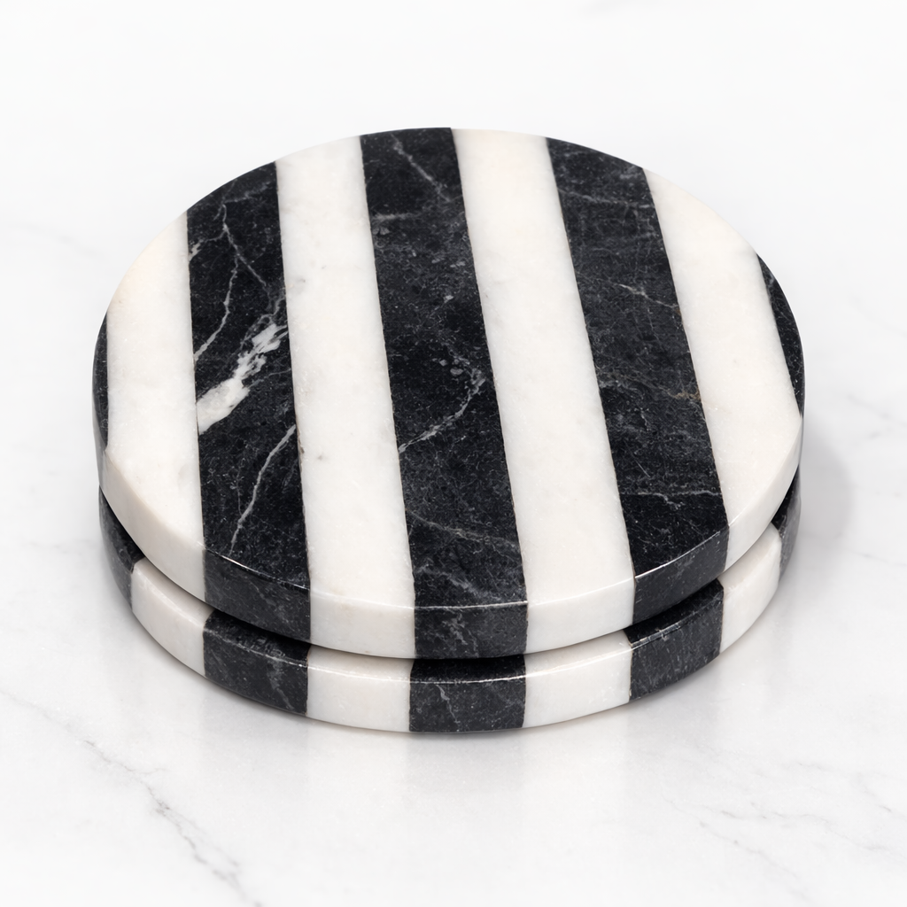 Set of black and white striped marble coasters on a white background