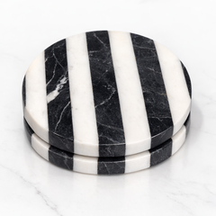Set of black and white striped marble coasters on a white background