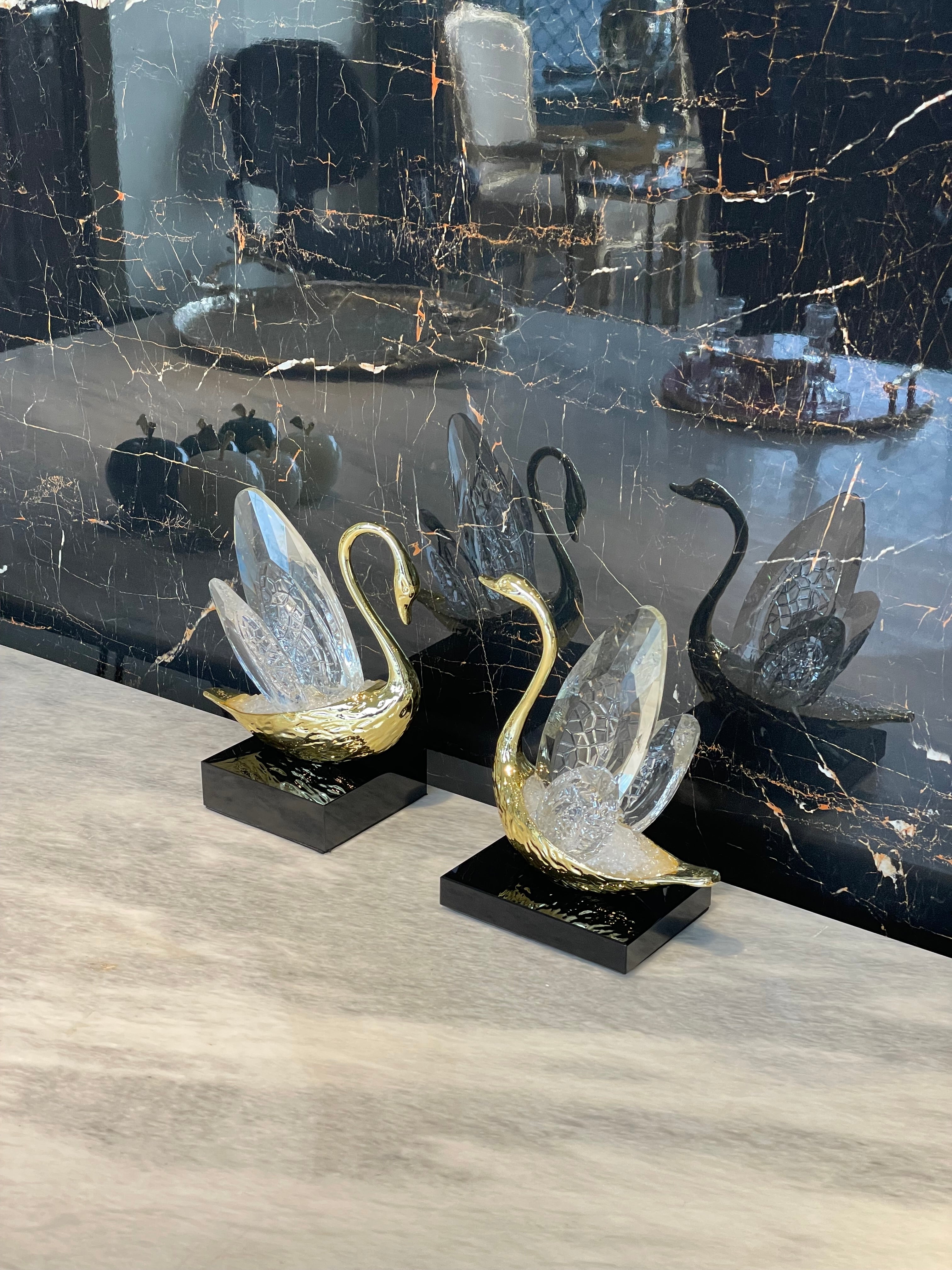Decorative glass swans on a textured surface