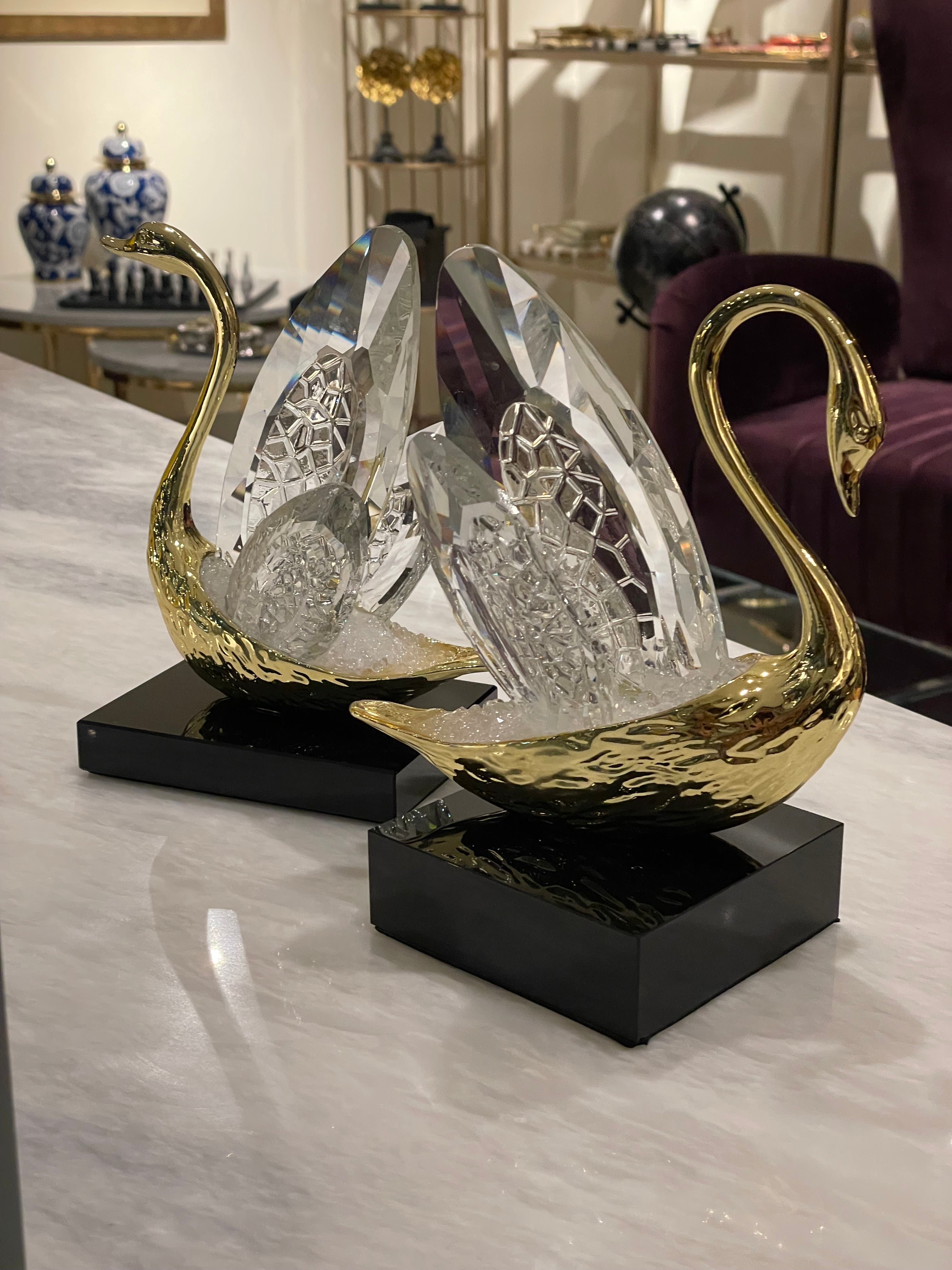 Decorative swan sculpture with gold and black accents on a white surface.