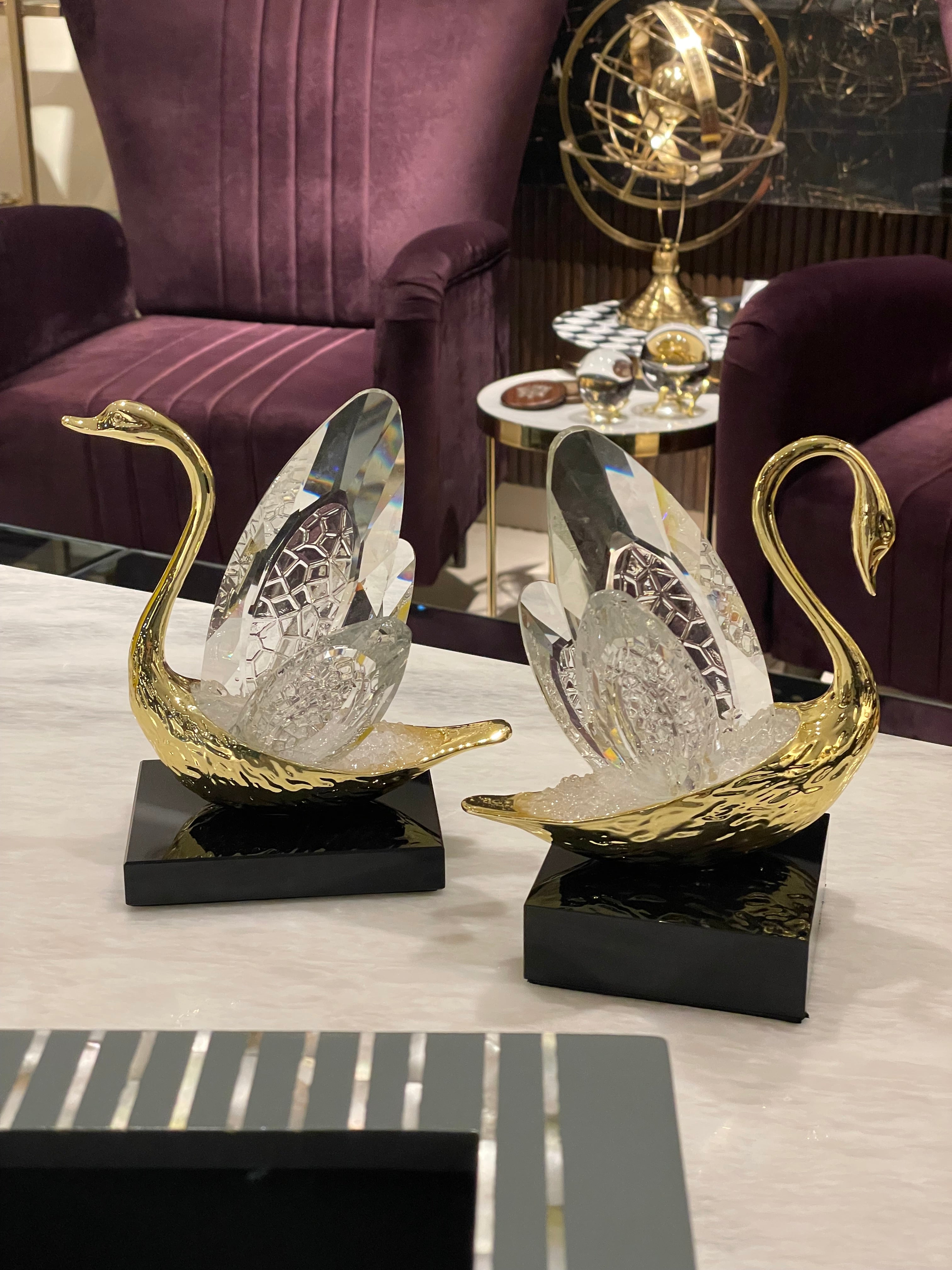 Decorative gold swan sculpture on a white surface with a blurred background