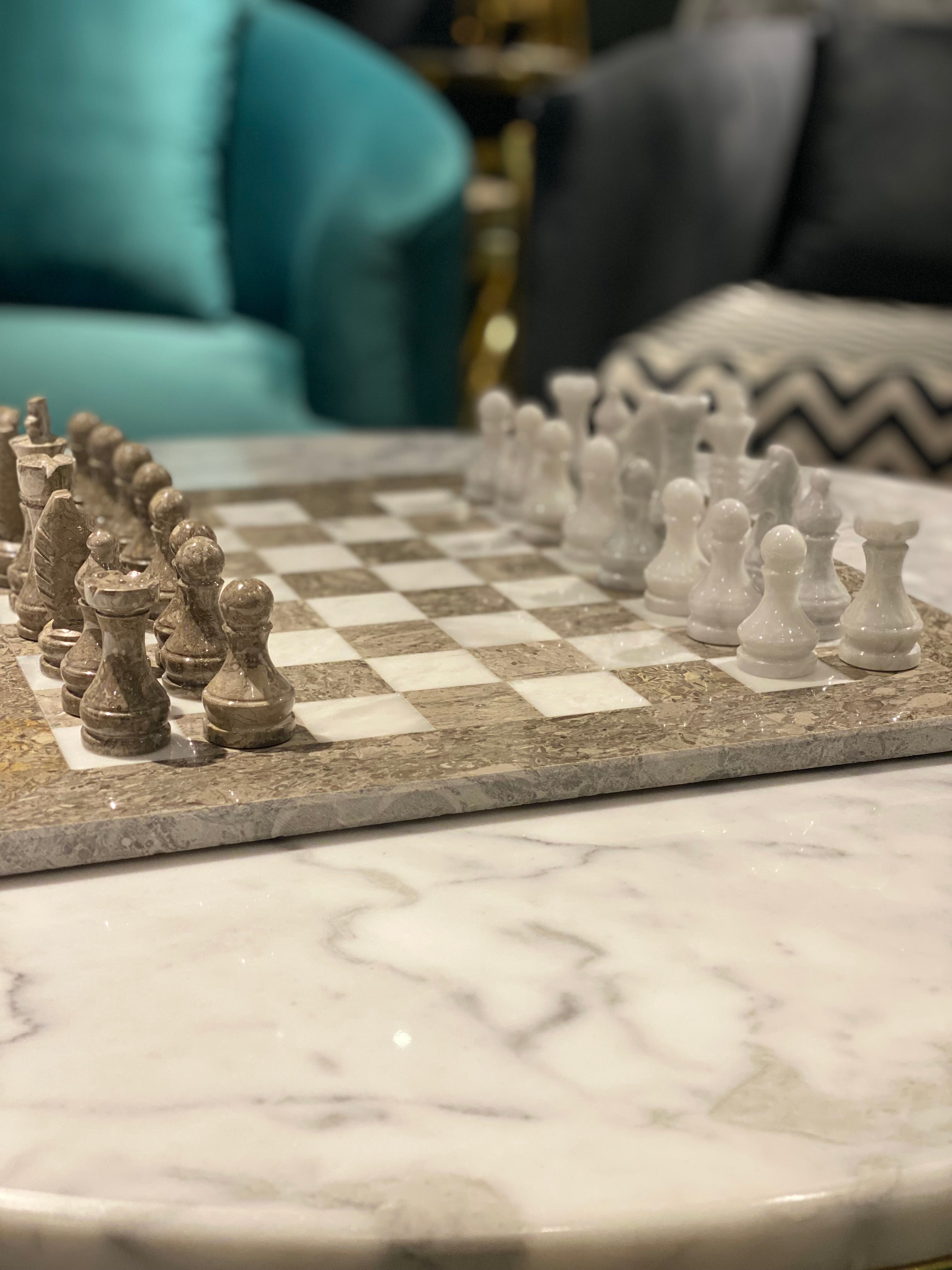 Chessboard with pieces on a marble surface, blurred background
