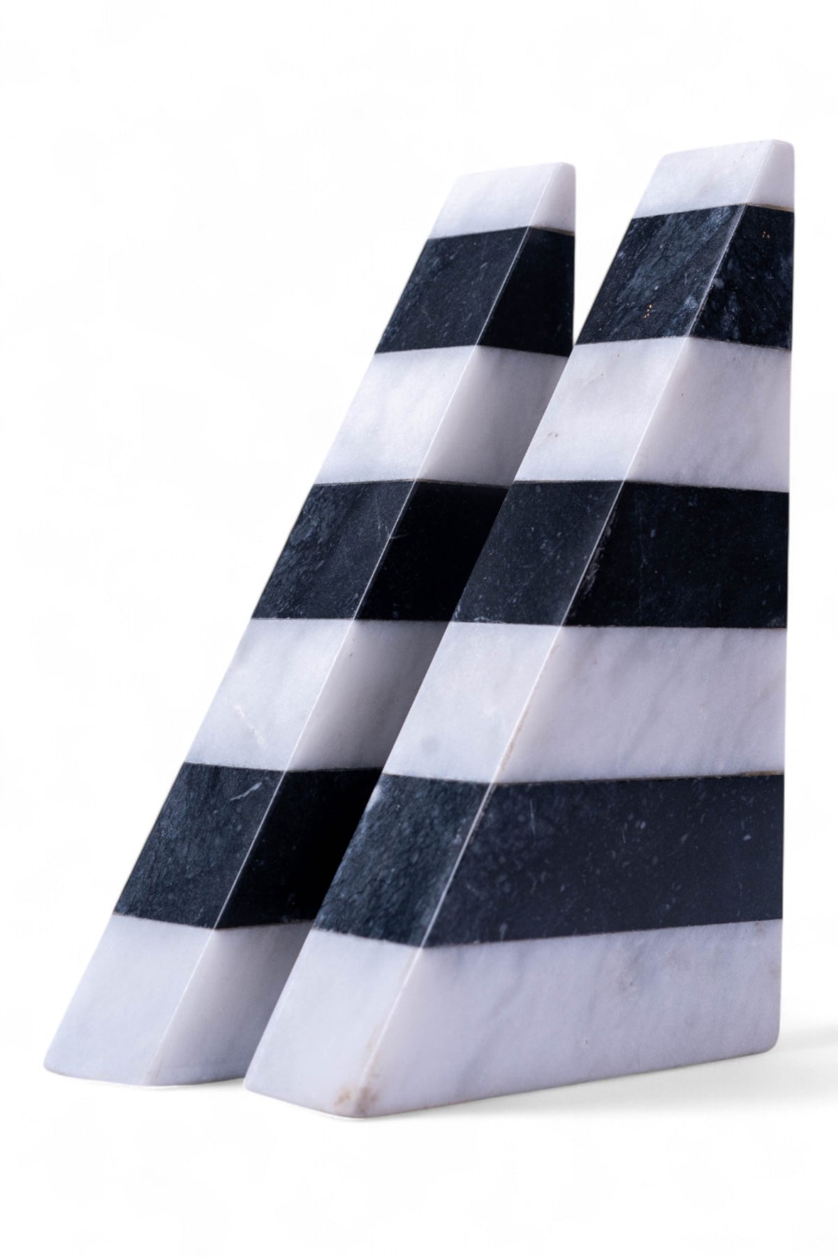 Two triangular marble blocks with black and white stripes on a white background