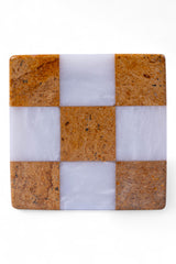 Checkered pattern coaster with brown and white squares on a white background
