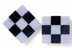 Two square marble coasters with black and white checkered pattern on a white background