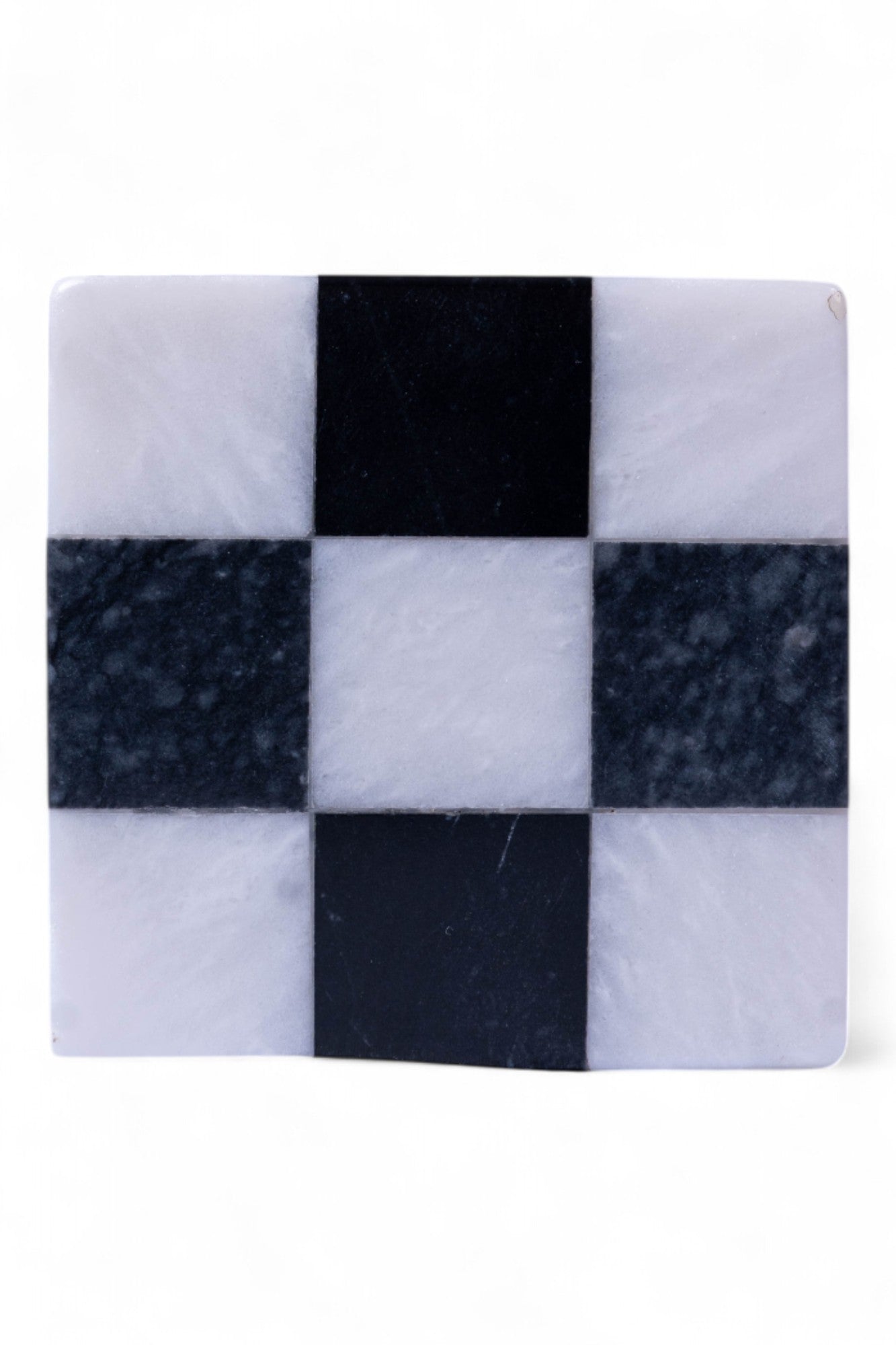 Checkered marble coaster with black and white squares on a white background