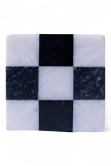 Checkered marble coaster with black and white squares on a white background