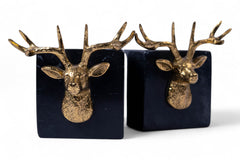 Two decorative bookends with gold deer heads on black bases.