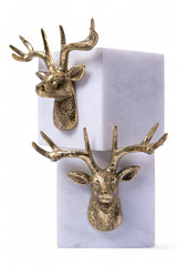 Gold deer head earrings on a white card with a marble background