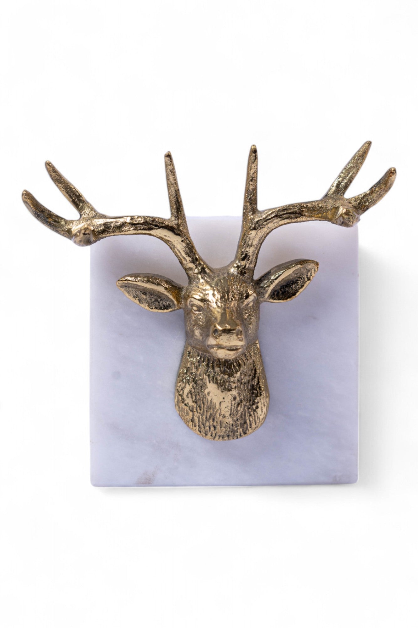 Gold deer head wall decoration on a purple marble base