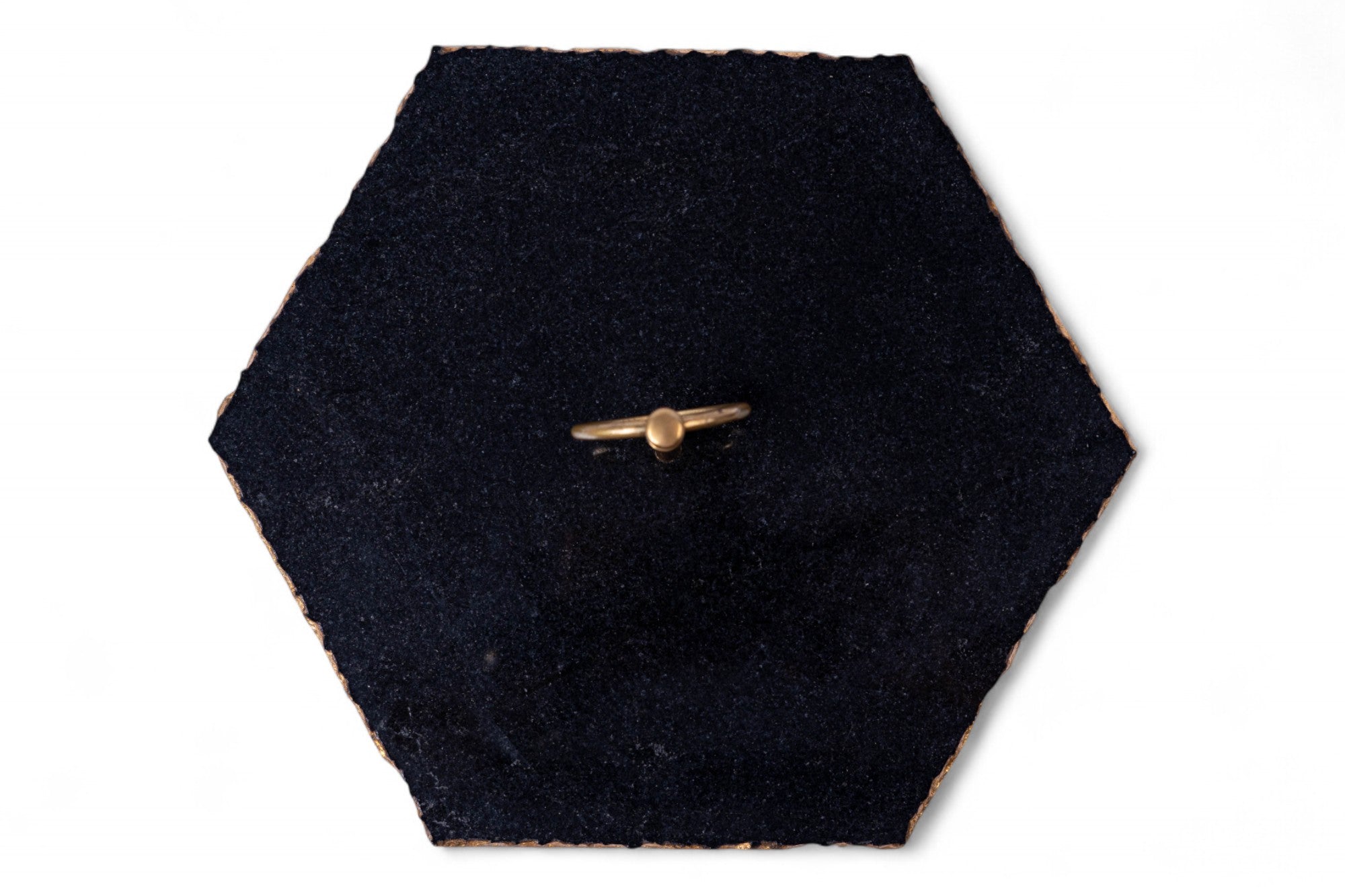 Gold airplane-shaped brooch on a black hexagonal fabric background
