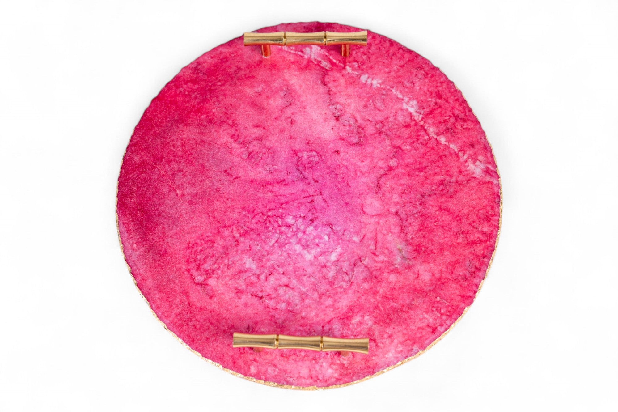 Round pink clutch with gold accents on a white background