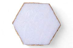 Hexagonal white stone coaster on a white background