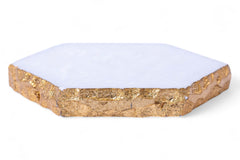 Hexagonal white coaster with gold edge on a white background
