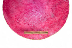 Pink textured clutch bag with a gold clasp on a white background