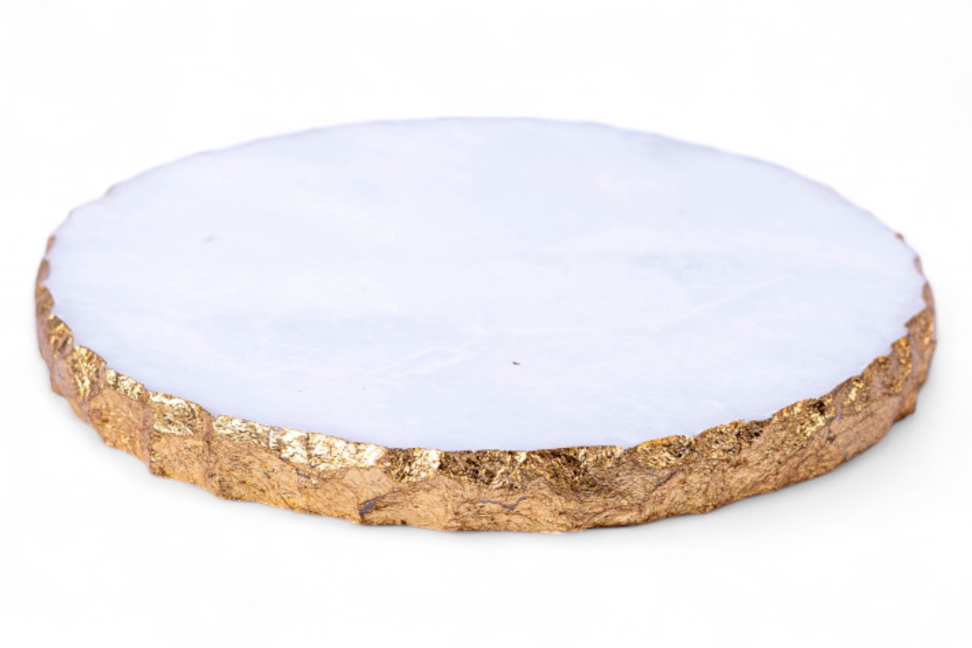Round coaster with gold rim and white center on a white background