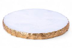 Round coaster with gold rim and white center on a white background