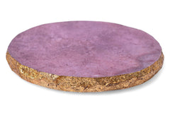 Round purple coaster with cork base on a white background