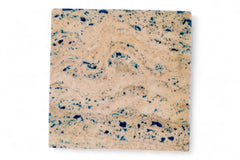 Square stone coaster with beige and blue speckled pattern on a white background