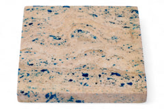 Square sponge with blue speckles on a white background
