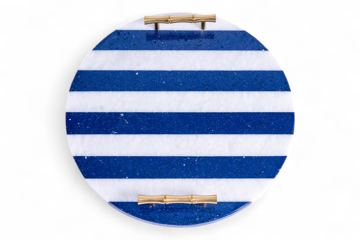 Round blue and white striped object with gold accents on a white background
