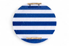 Round blue and white striped object with gold accents on a white background