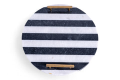 Round marble cutting board with black and white stripes on a white background
