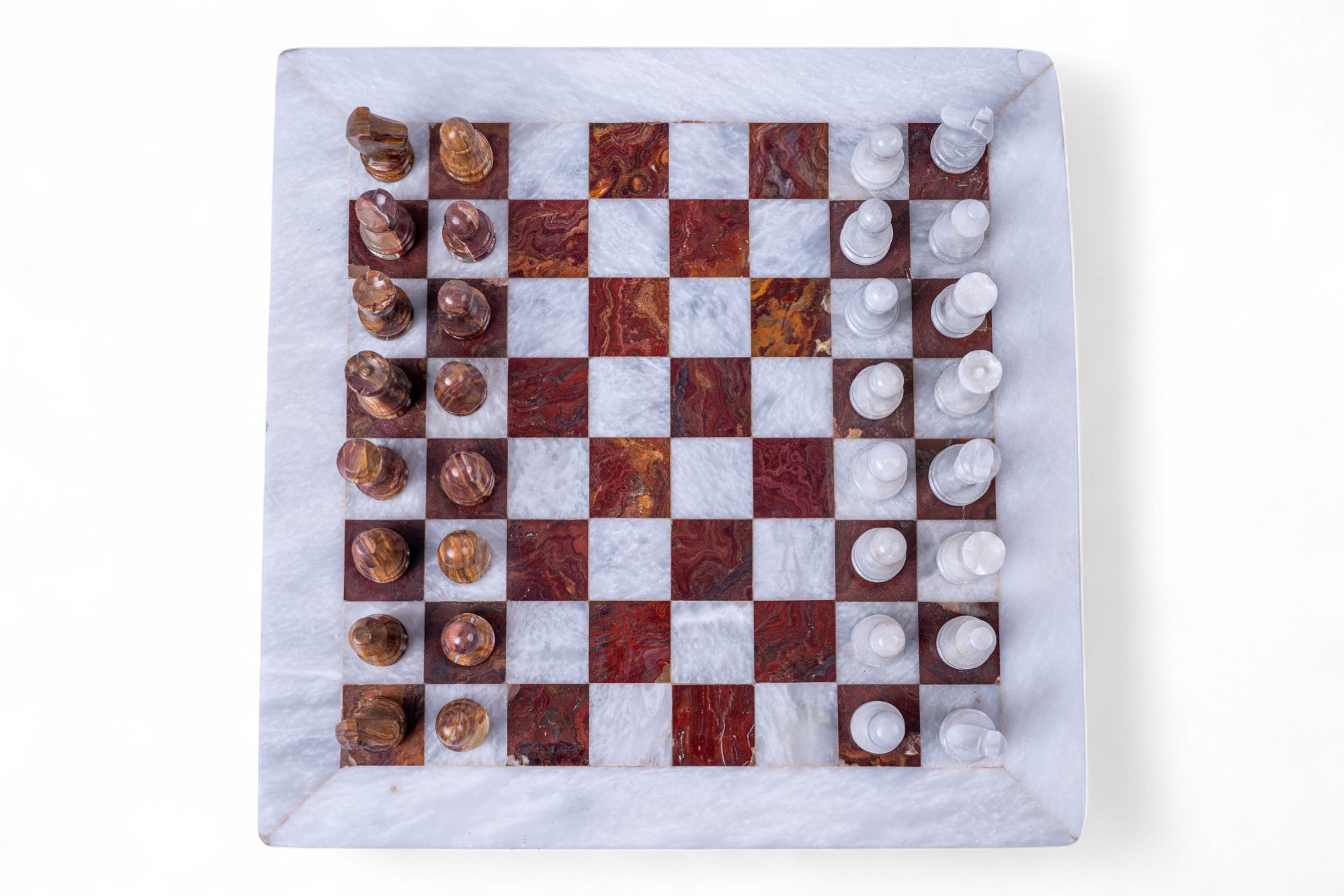 Marble chessboard with chess pieces on a white background