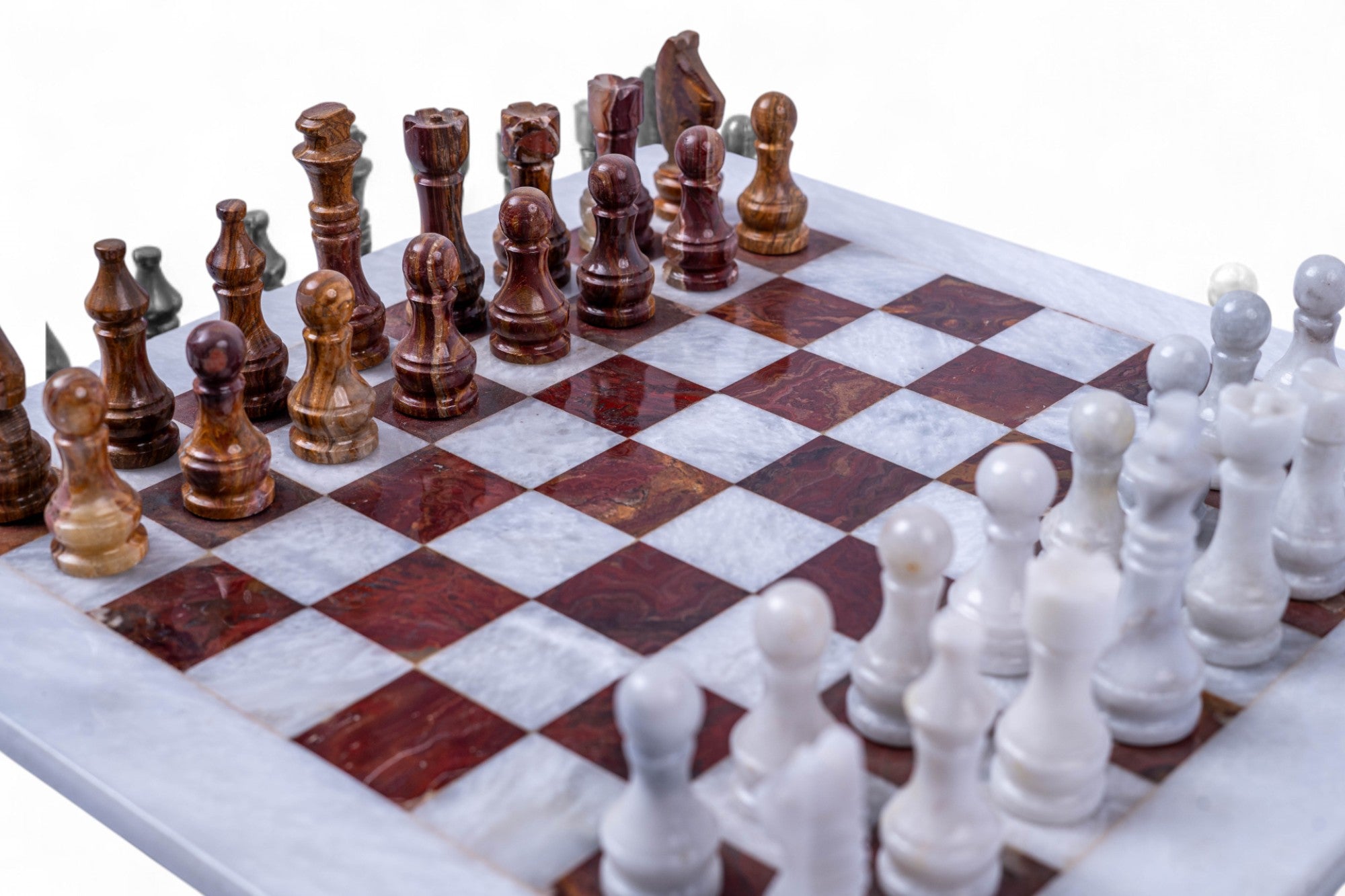 Marble chessboard with wooden and white chess pieces on a white background