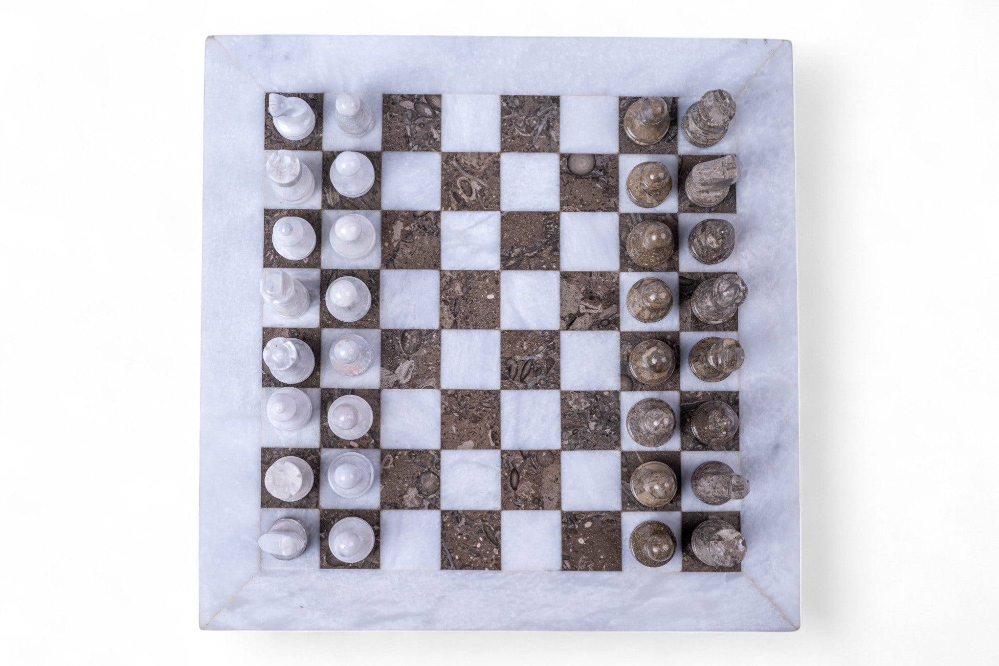 Marble chessboard with stone pieces on a white background
