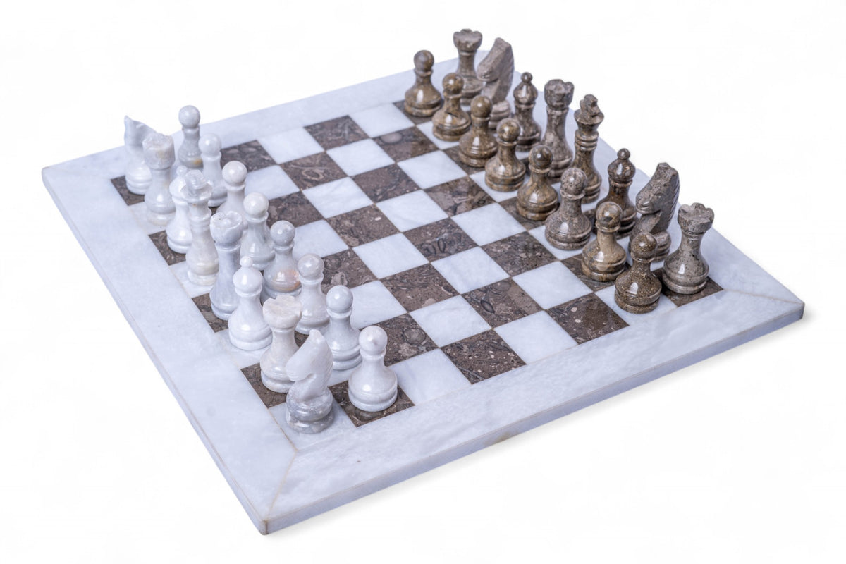 Marble chess set with white and silver pieces on a white background