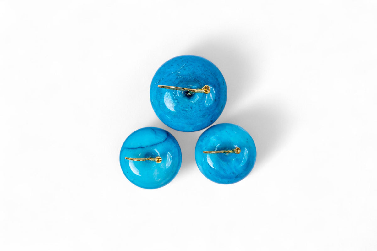 Set of three blue earrings on a white background