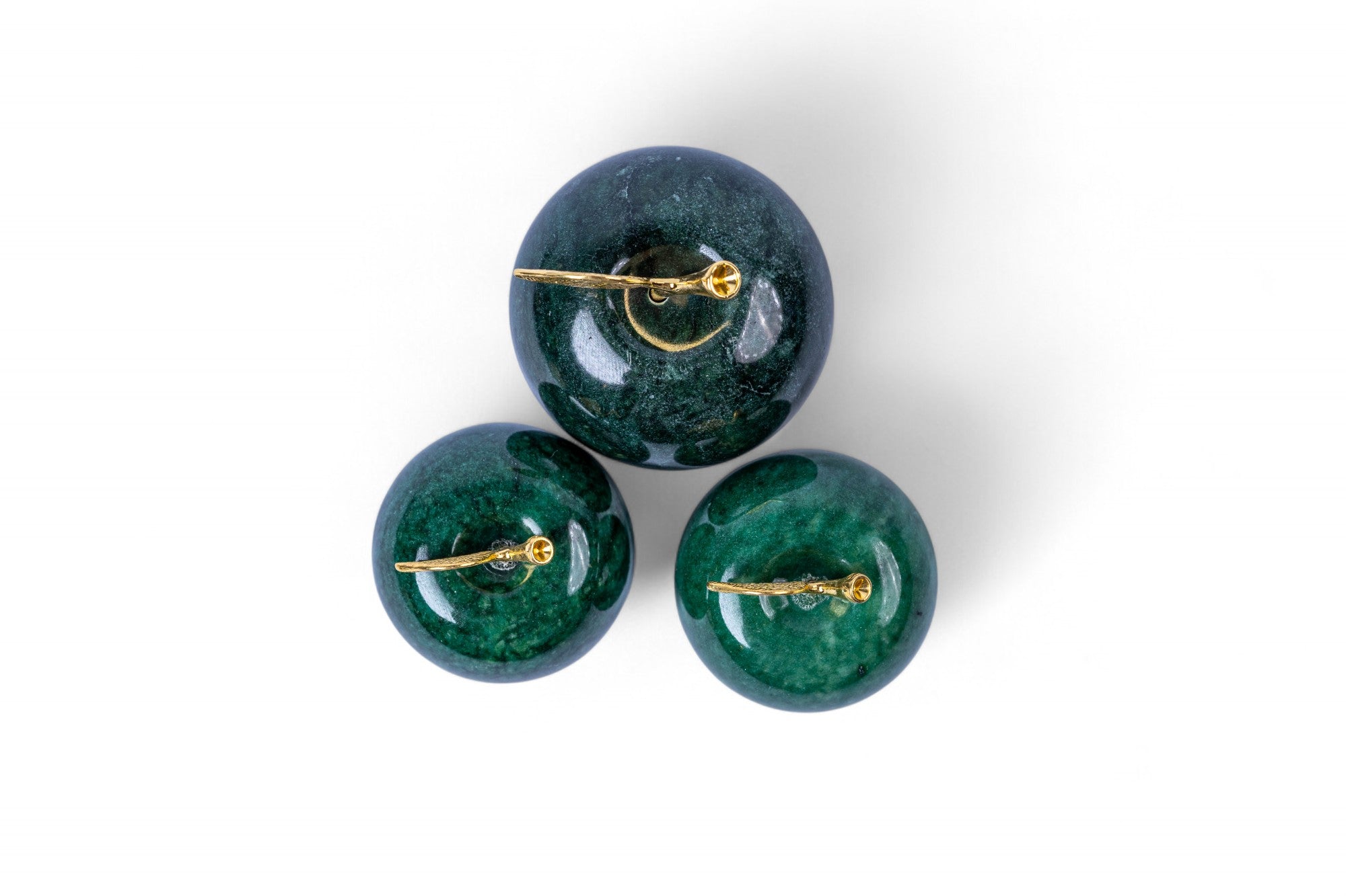 Three green gemstone earrings with gold clasps on a white background