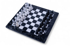 Black and white chess pieces on a checkered board with a marble-like finish.