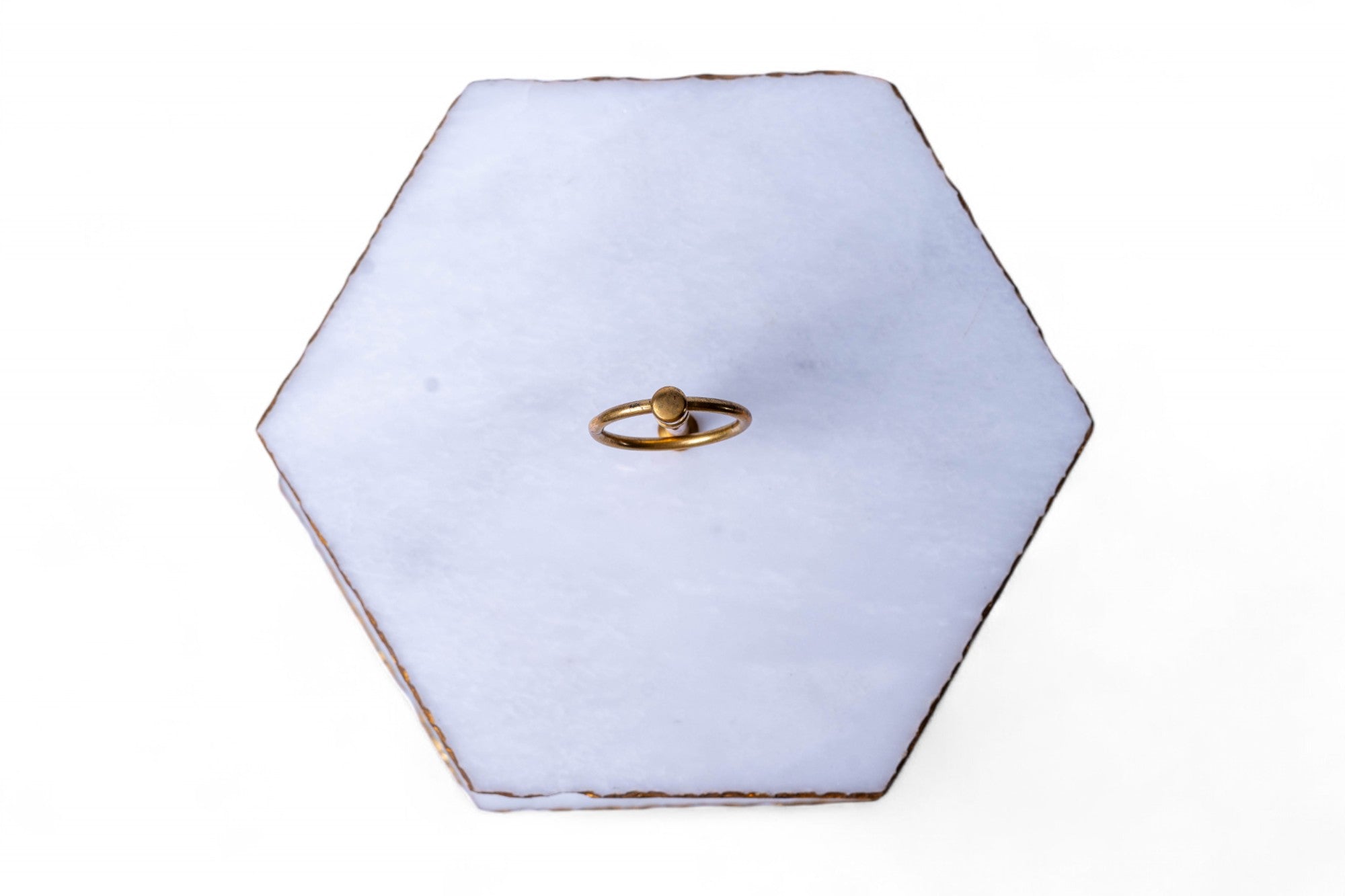 Hexagonal white jewelry box with a gold ring on a white background