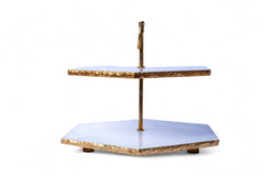 Two-tiered decorative stand with gold and white design on a white background