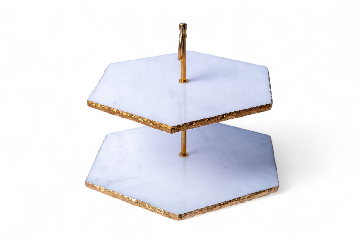 Two-tiered cake stand with gold accents on a white background