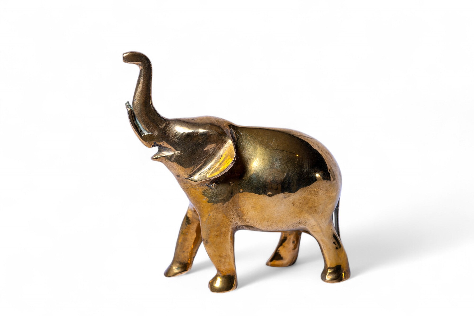 Brass elephant figurine on a white background