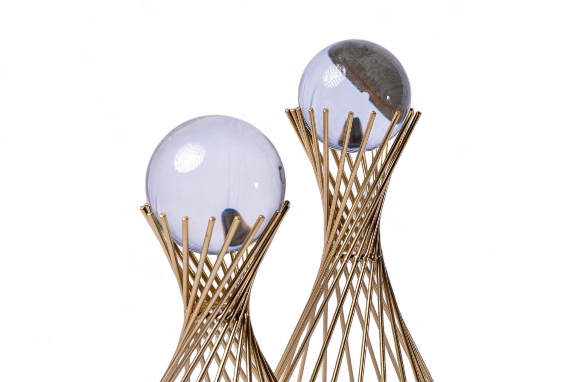 Decorative object with glass spheres and gold wire base on a white background