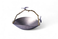 Decorative metal bowl with branch handle and bird accents on a white background