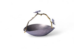 Decorative metal bowl with a handle featuring butterfly designs on a white background