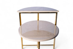 Two-tiered side table with gold legs on a white background
