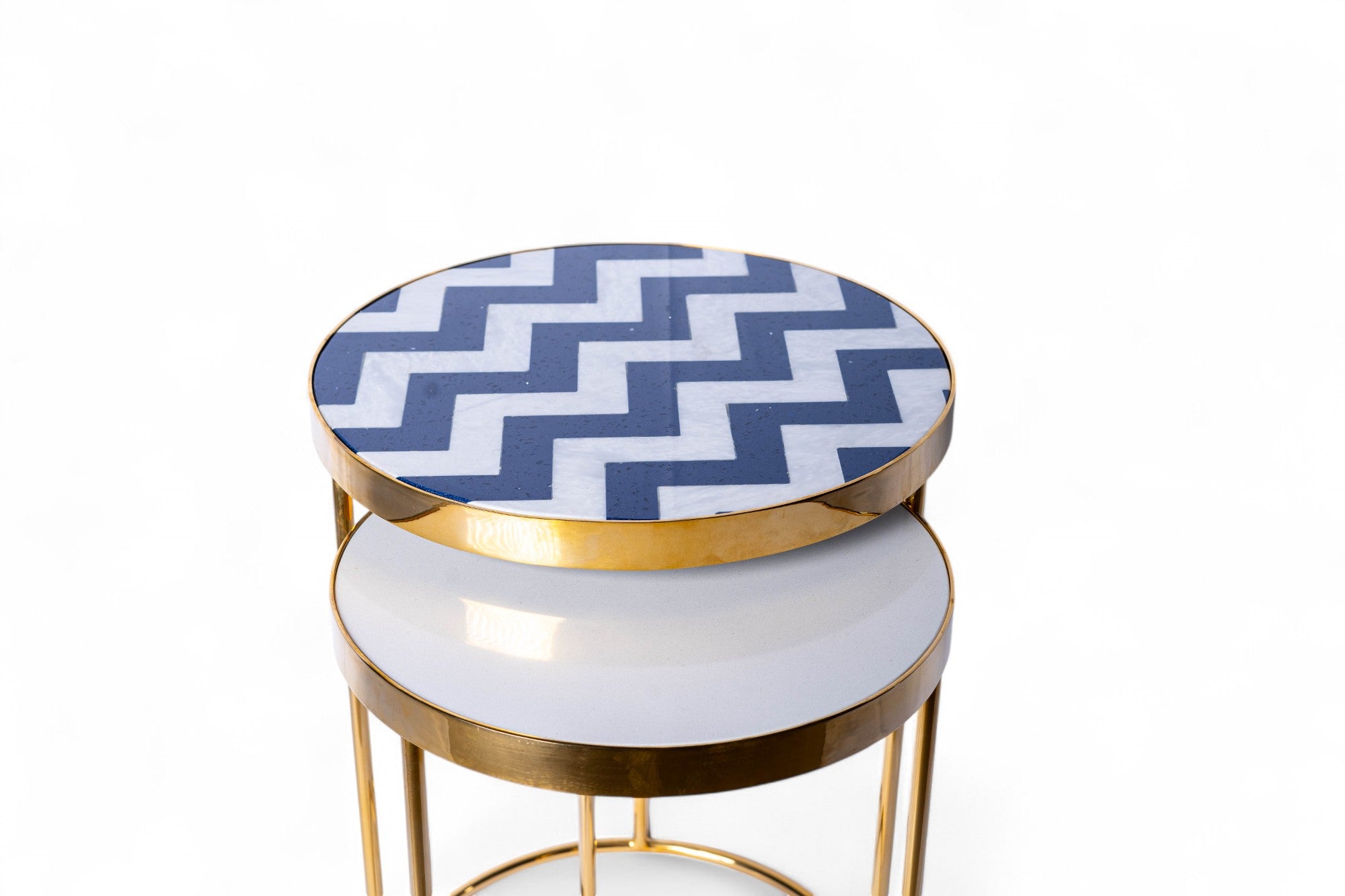 Round side table with blue and white chevron pattern top on a white background