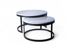 Set of two round marble coffee tables with black metal frames on a white background